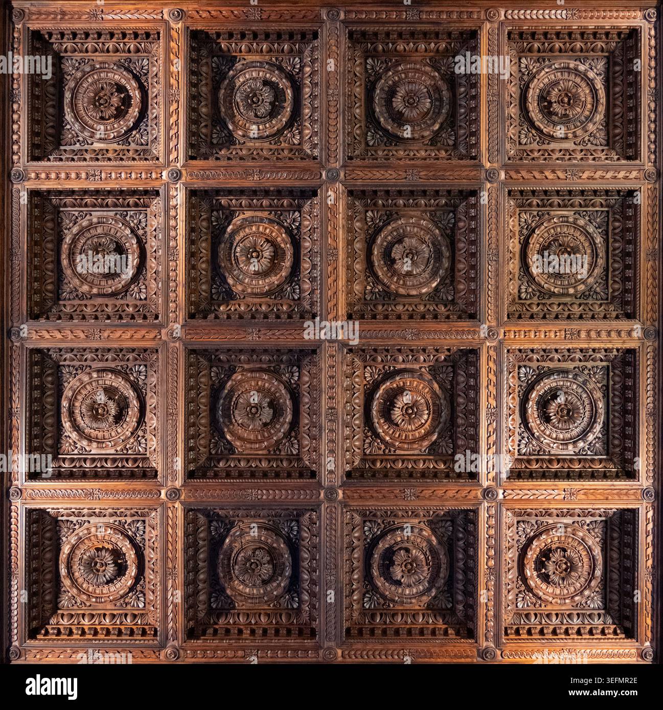 Soffitto a cassettoni in legno intagliato simmetrico con rosette floreali all'interno di Palazzo Pitti a Firenze, Toscana, Italia. Foto Stock
