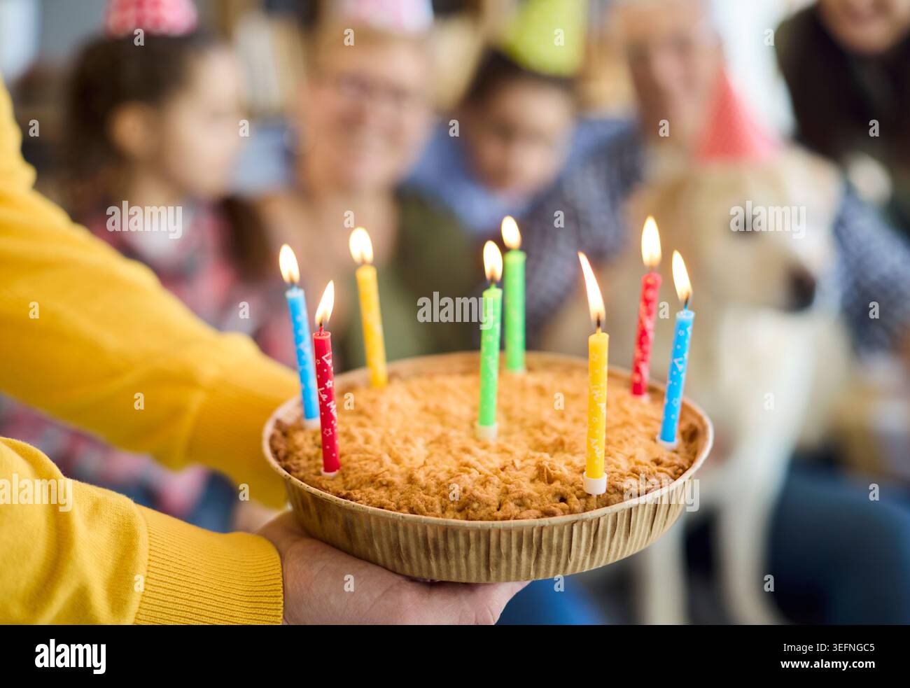 Primo piano torta di compleanno con candele alla festa di famiglia in un'accogliente casa multigenerazionale Foto Stock