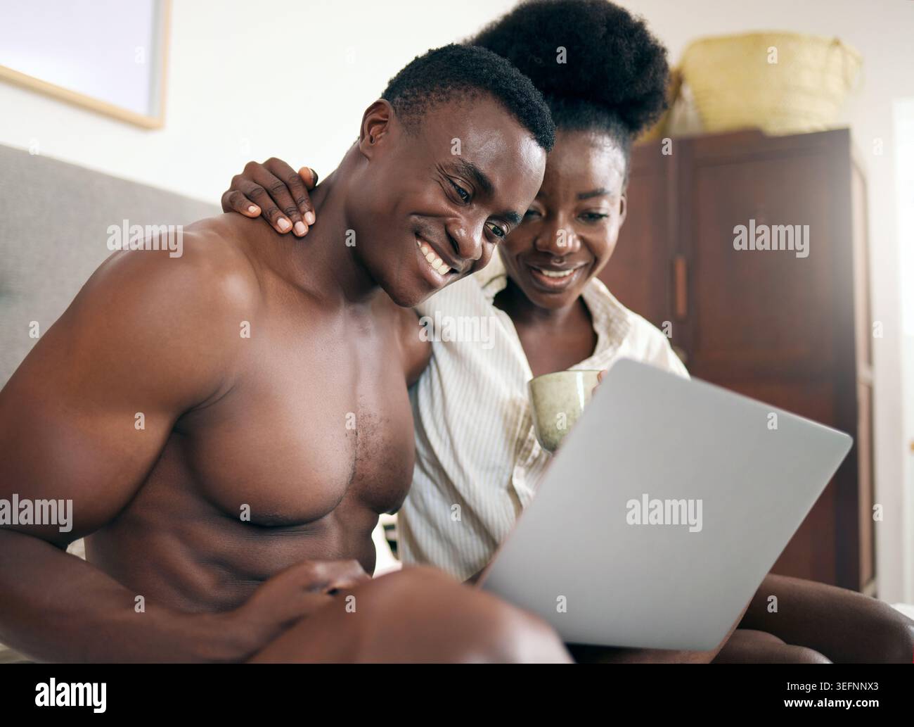 Laptop, amore e coppia in camera da letto con ricerca online, Internet o servizio di streaming a casa. Romanticismo, vacanze e persone di colore con computer per Foto Stock