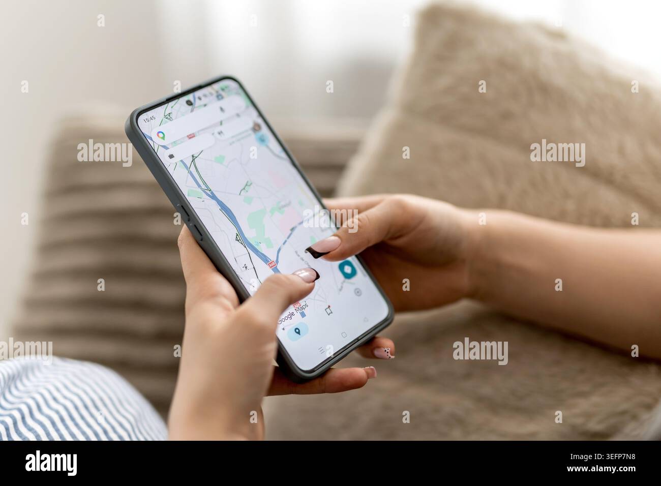 GNIEZNO, POLONIA - 06 maggio 2026: Le mani delle donne scorrono su Google Maps su Uno smartphone visto dall'alto Foto Stock