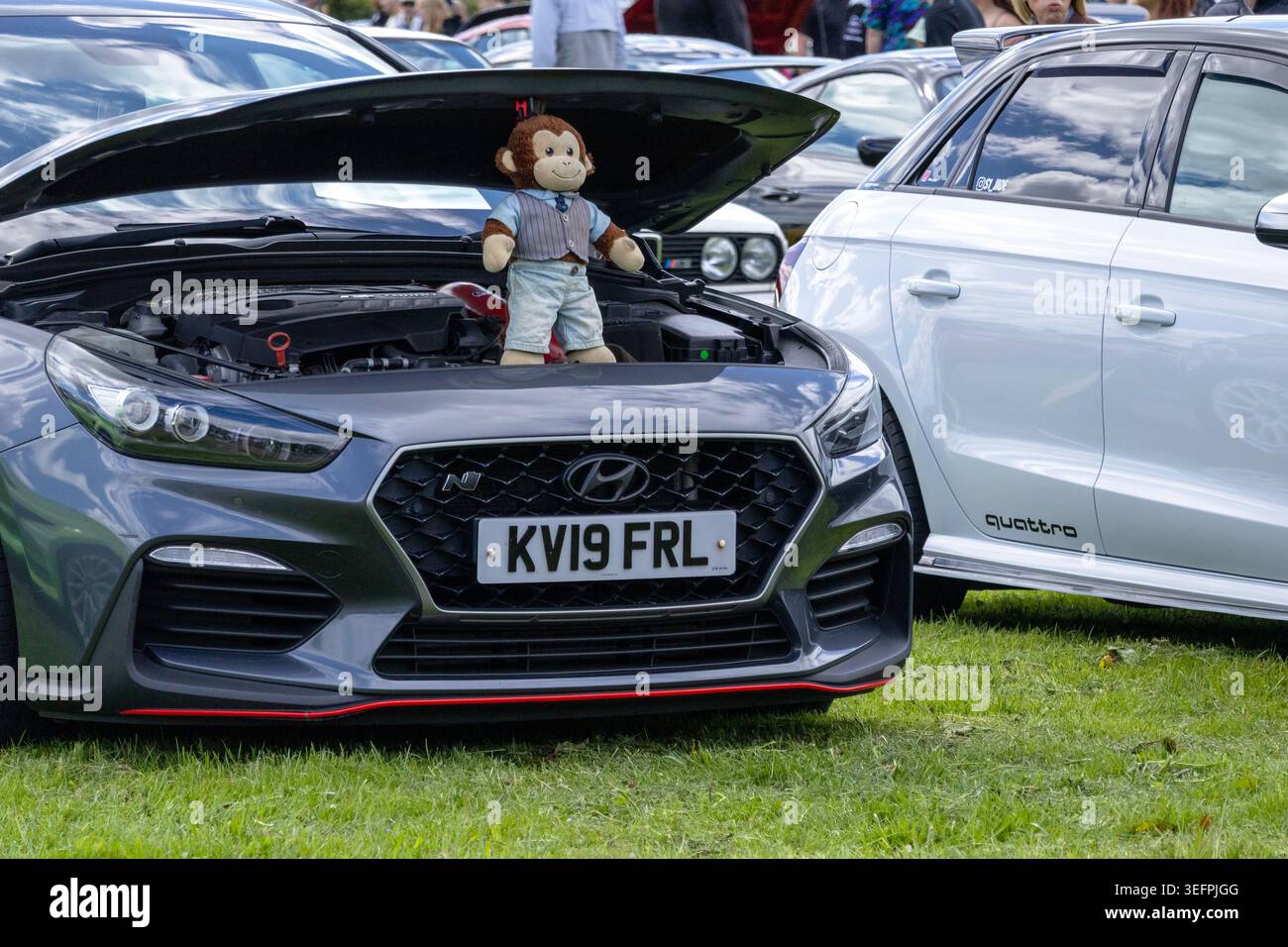 Una Hyundai i30 N hatchback ad alte prestazioni con il cofano aperto e un giocattolo di peluche a forma di scimmia seduto sul blocco motore. Foto Stock
