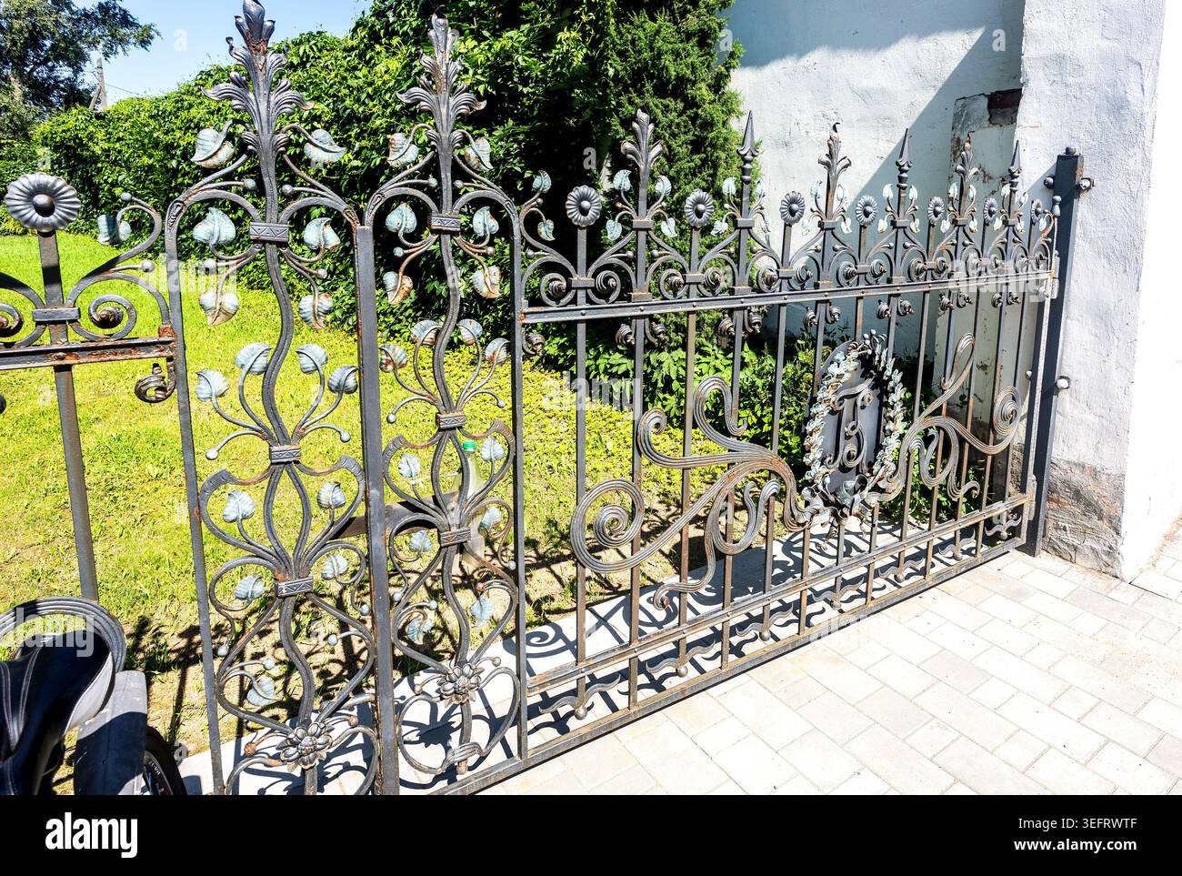 Borovichi, Russia - 17 luglio 2025: Griglia forgiata in metallo antico con elementi decorativi su una strada della città. Griglia di recinzione di ferro Foto Stock