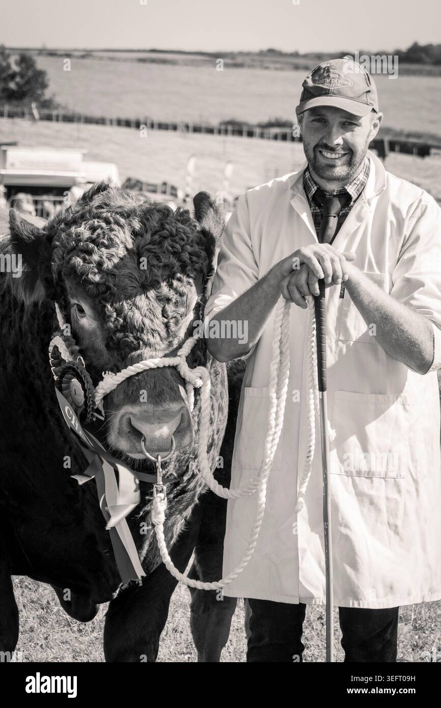 John Tucker, di East Prawle, Devon, con il suo premio Red Devon Bull, al South Devon Show, 2025 Foto Stock