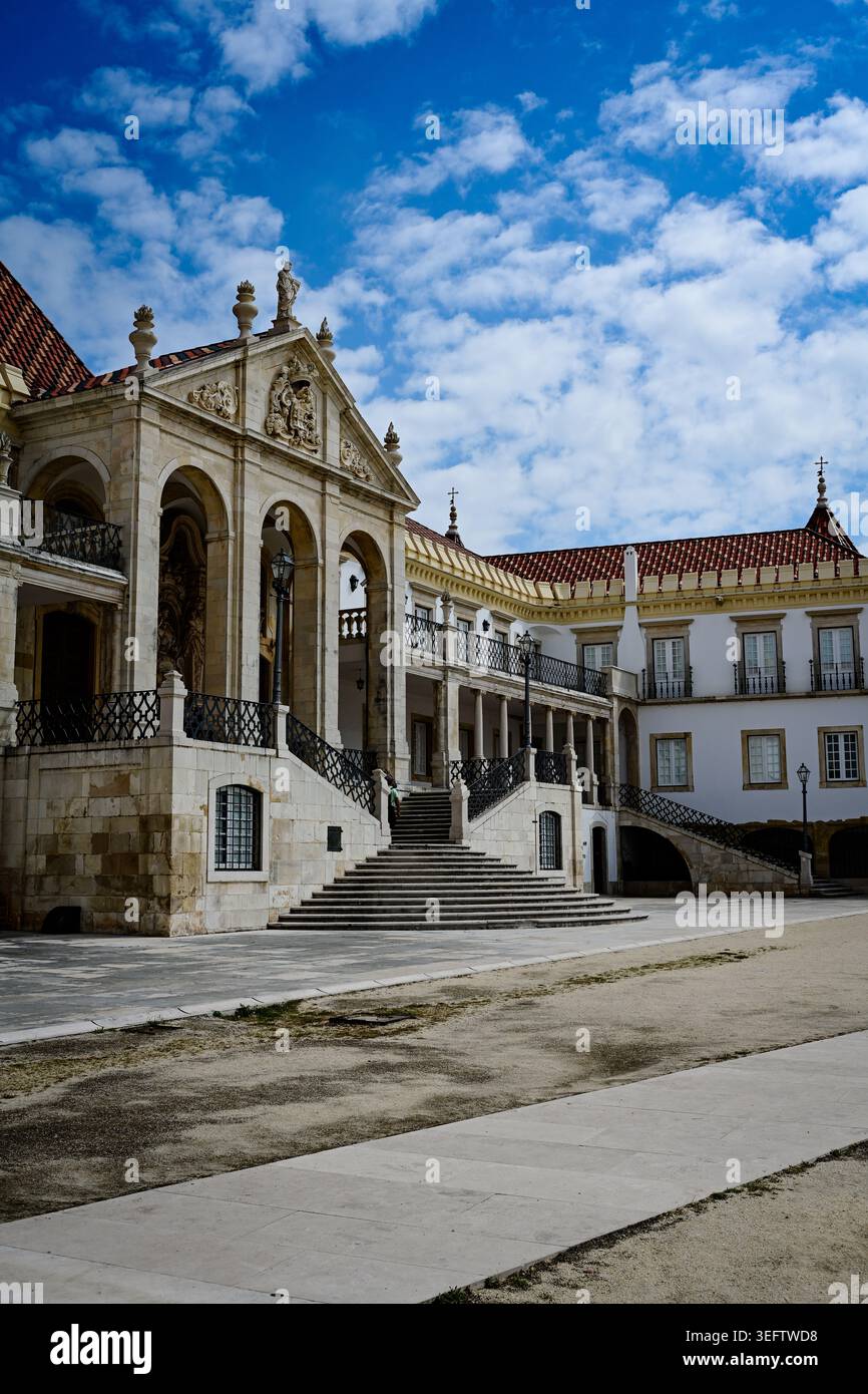 Un grande palazzo storico con ampie scale e architettura classica si erge sotto i vibranti cieli blu e le nuvole che si muovono. Il raffinato stonewo Foto Stock