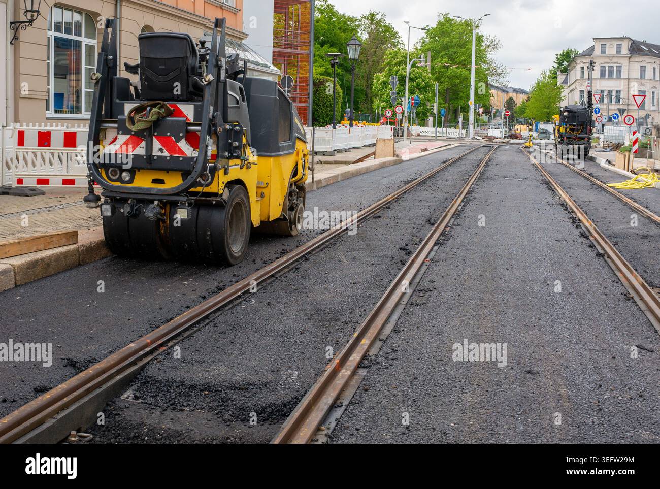 Riabilitazione della rete ferroviaria della città con asfalto e rulli Foto Stock