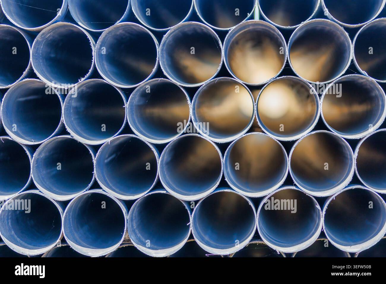 Pila astratta di tubi con luce alla fine, futuristico sfondo del tunnel. Foto Stock
