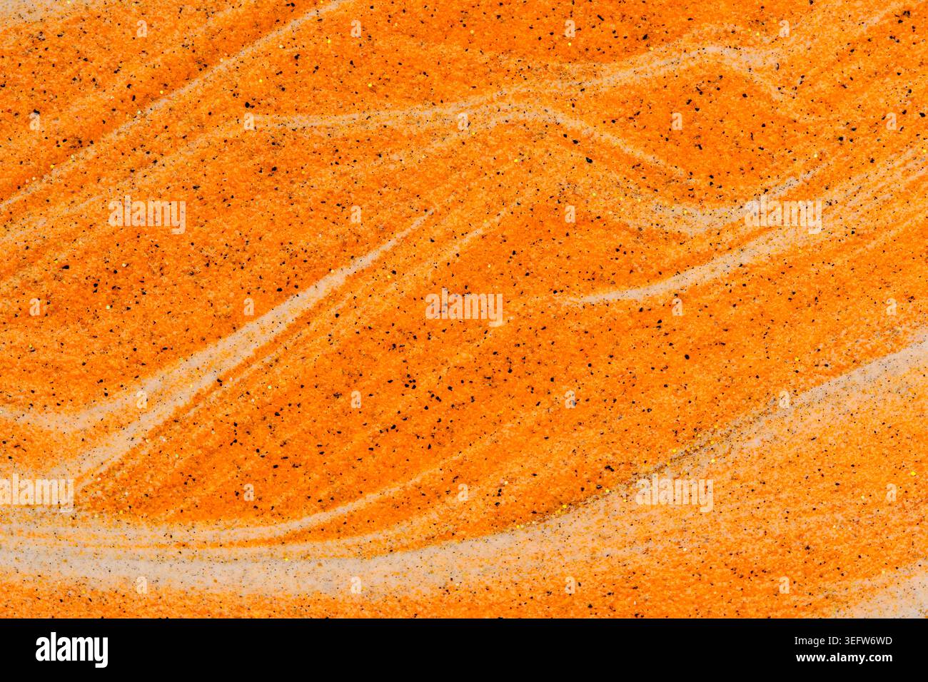 Sabbia arancione con consistenza full frame con particelle scure, vortici e scintillanti scintillanti Foto Stock