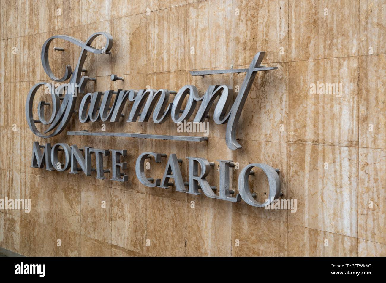 Monaco, Monaco 12 aprile 2026 il cartello metallico dell'hotel Fairmont Monte Carlo è montato su una parete in marmo a Monaco. Immagine stock del marchio di lusso per il settore alberghiero Foto Stock