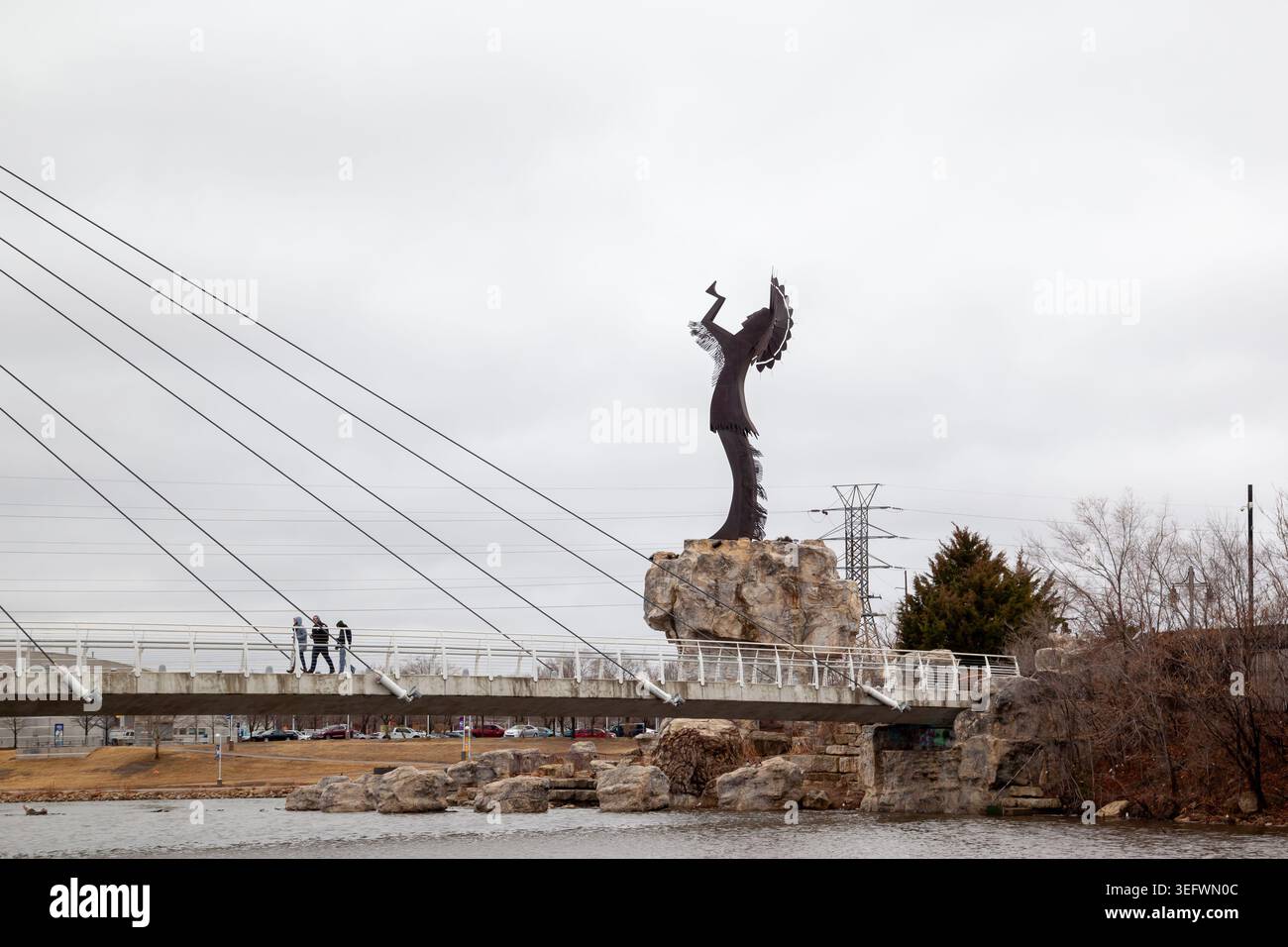 La scultura in acciaio "Custode of the Plains" con ponte pedonale alla confluenza dei fiumi Arkansas e Little Arkansas a Wichita, Kansas. Foto Stock