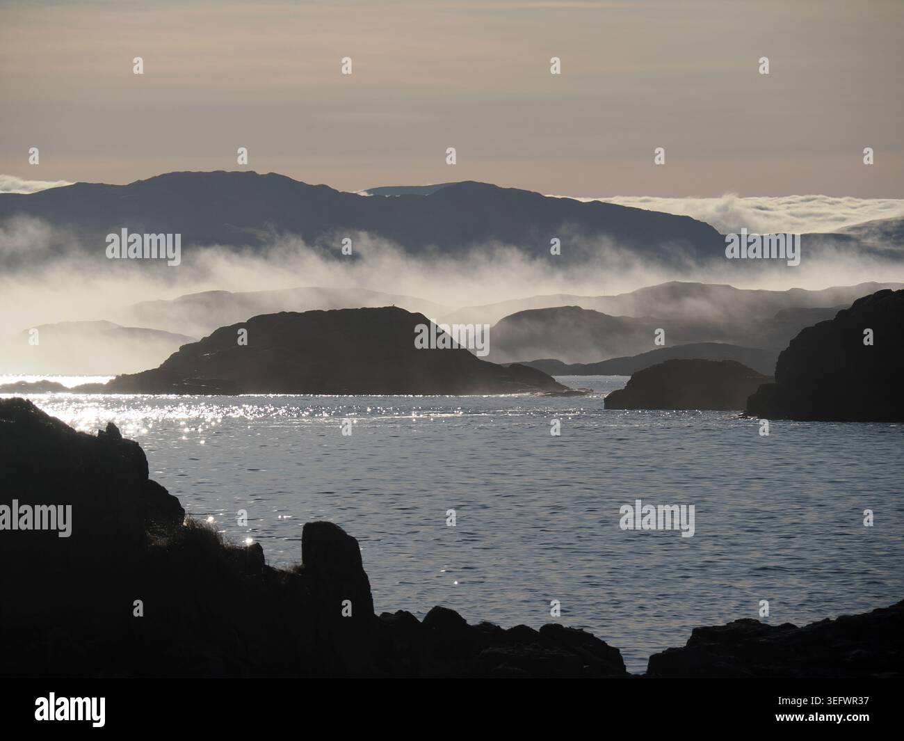 Sole e nebbia mattutini dall'isola di Oldany, Scozia Foto Stock