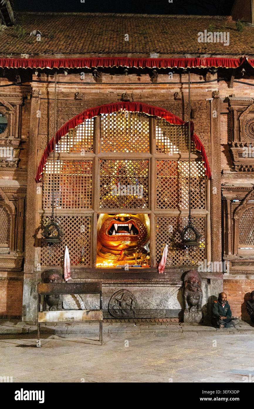 Maschera dorata di Bhairava bagnata (o Bhairava bianco) dietro un reticolo di legno a Kathmandu Durbar Square, Kathmandu, Nepal Foto Stock