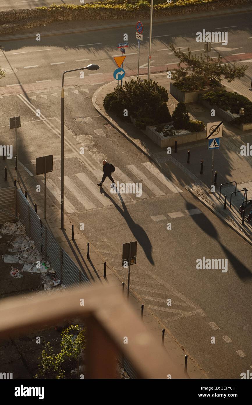 Ombre che attraversano l'attraversamento pedonale urbano Foto Stock