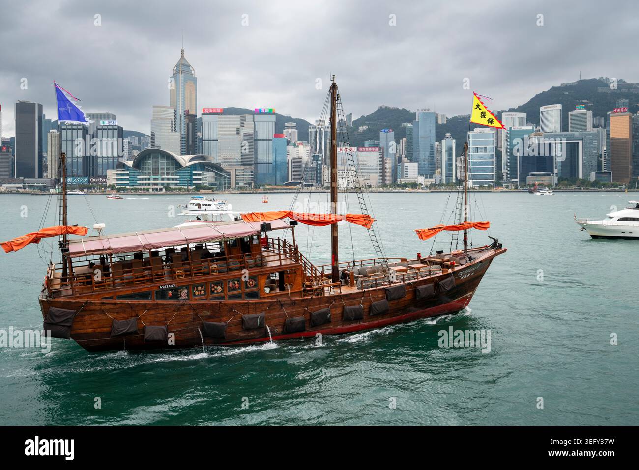 Tradizionale Junk Boat cinese in barca a vela nel Victoria Harbour con l'iconico skyline di Hong Kong, Hong Kong Foto Stock
