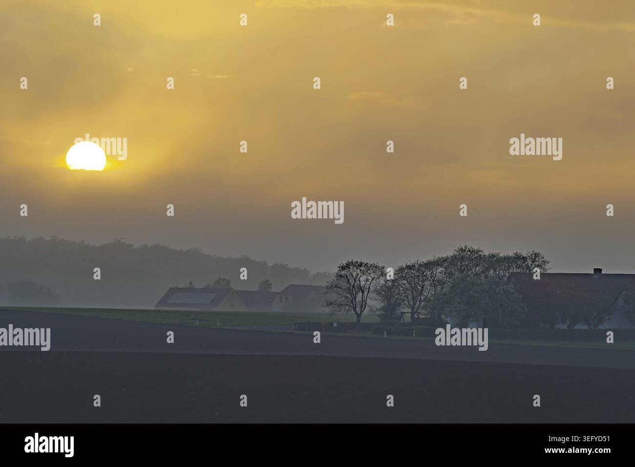 Un calmo tramonto che bagna il paesaggio e il cielo in una luce calda, Bornholm, Danimarca Foto Stock
