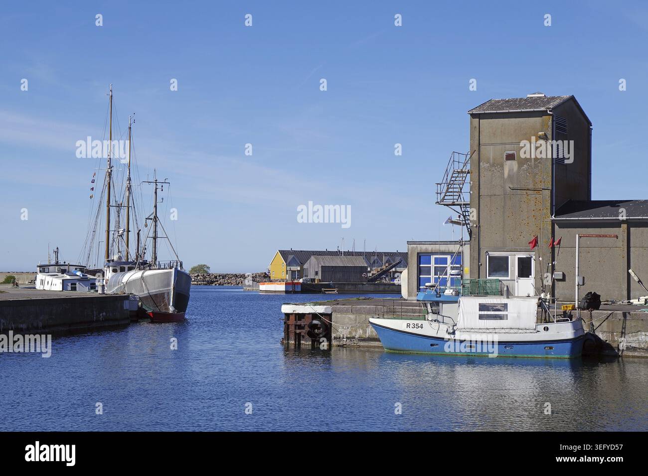 Un porto tranquillo con diverse piccole barche ed edifici rustici in condizioni di sole, Hasle, Bornholm, Danimarca Foto Stock