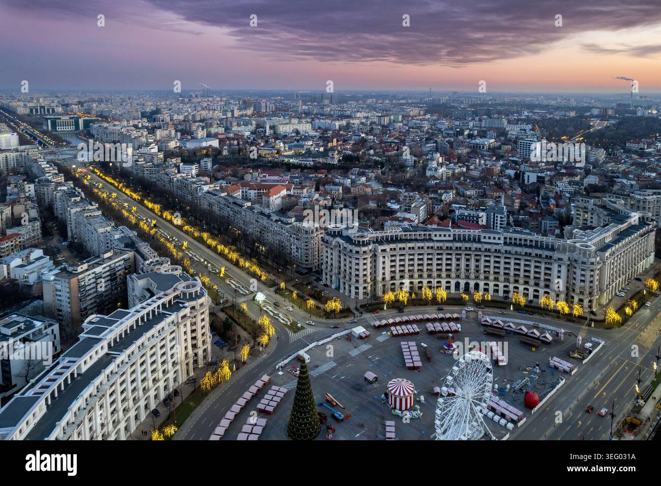 Vista aerea al crepuscolo di Bucarest, Romania, Europa, con il mercato di Natale di Piazza della Costituzione, i viali illuminati e lo skyline del Palazzo del Parlamento Foto Stock