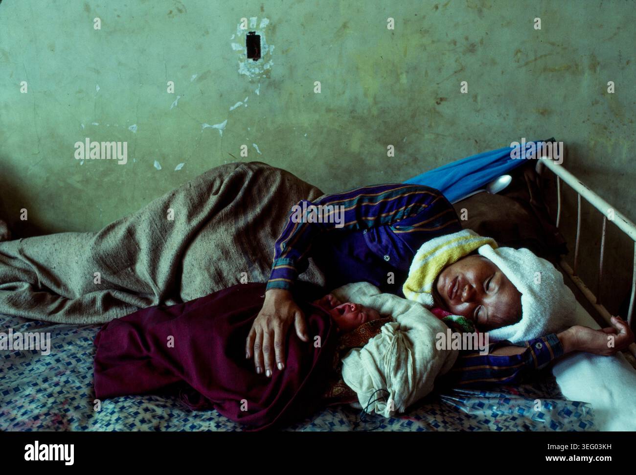 Provincia di Takeo, Cambogia: Una madre si riprende dal parto mentre la figlia dorme all'ospedale di Takeo. Foto Stock