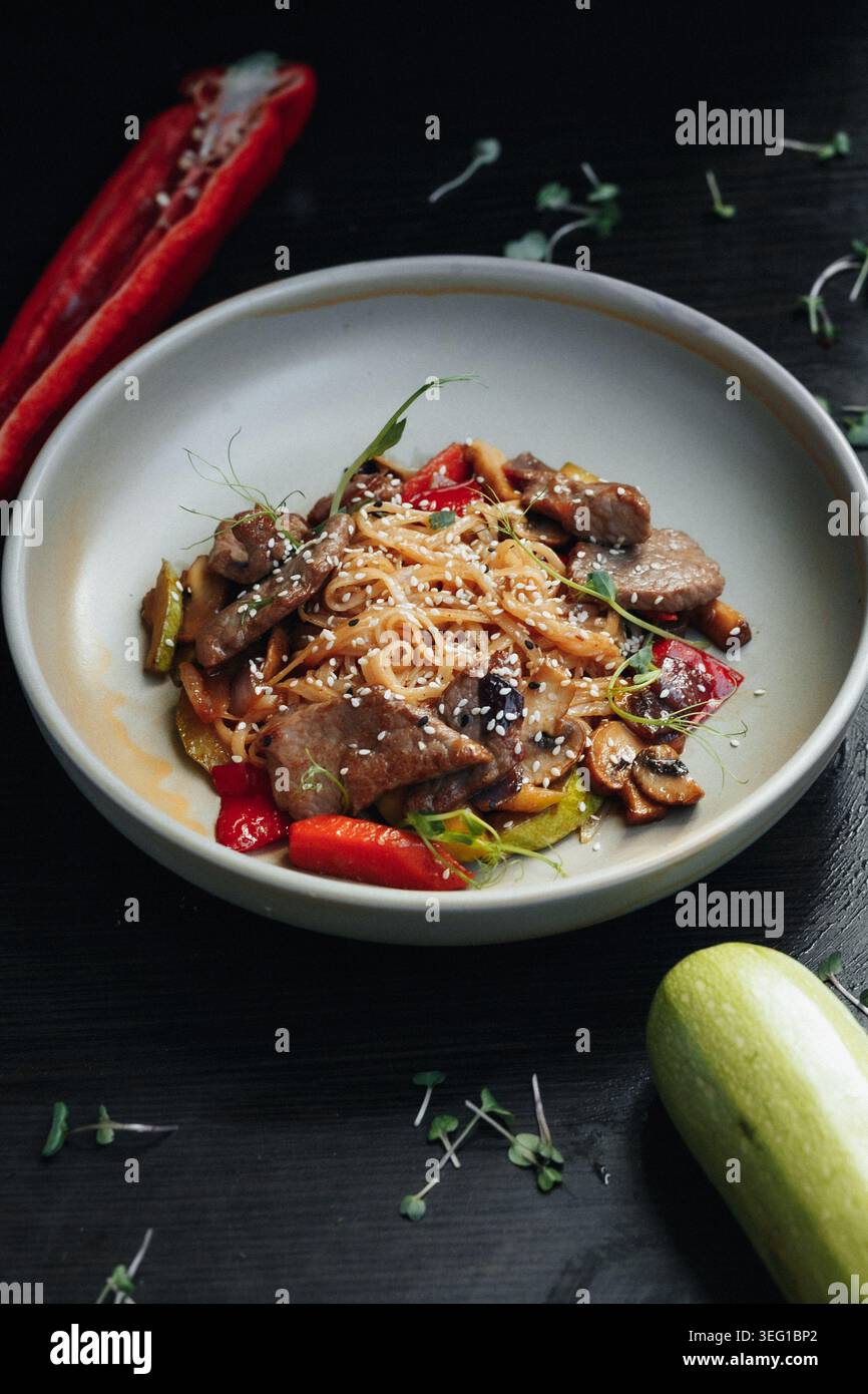 Colorato piatto di spaghetti di ispirazione asiatica servito in una ciotola bianca Foto Stock