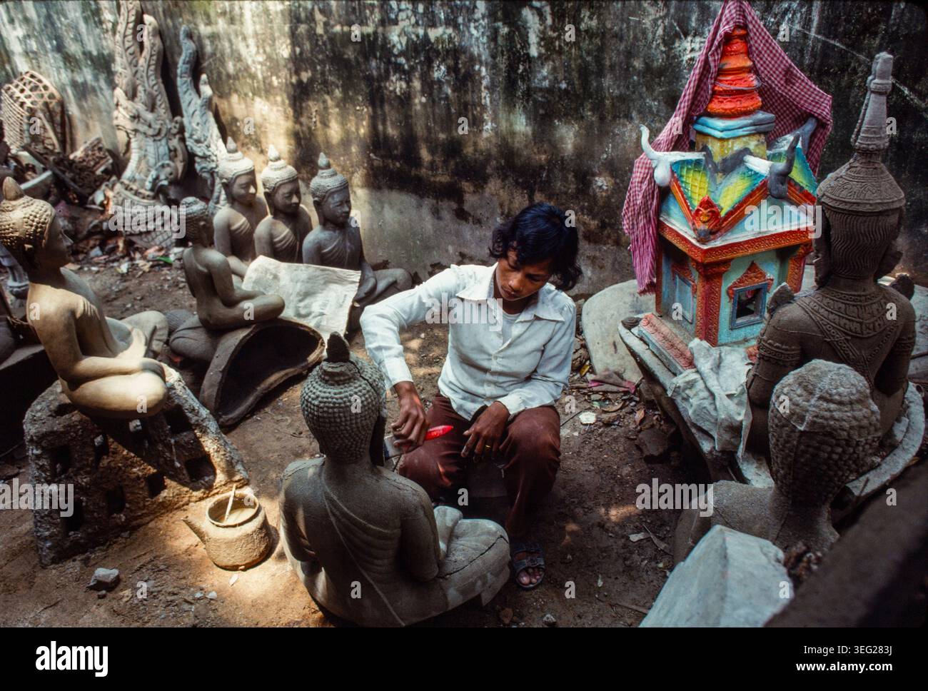 Un'artigiana prepara una statua di Buddha che sono state gettate a metà in stampi. Questo fa parte del ristabilimento del buddismo dopo la caduta degli khmer rossi. Foto Stock