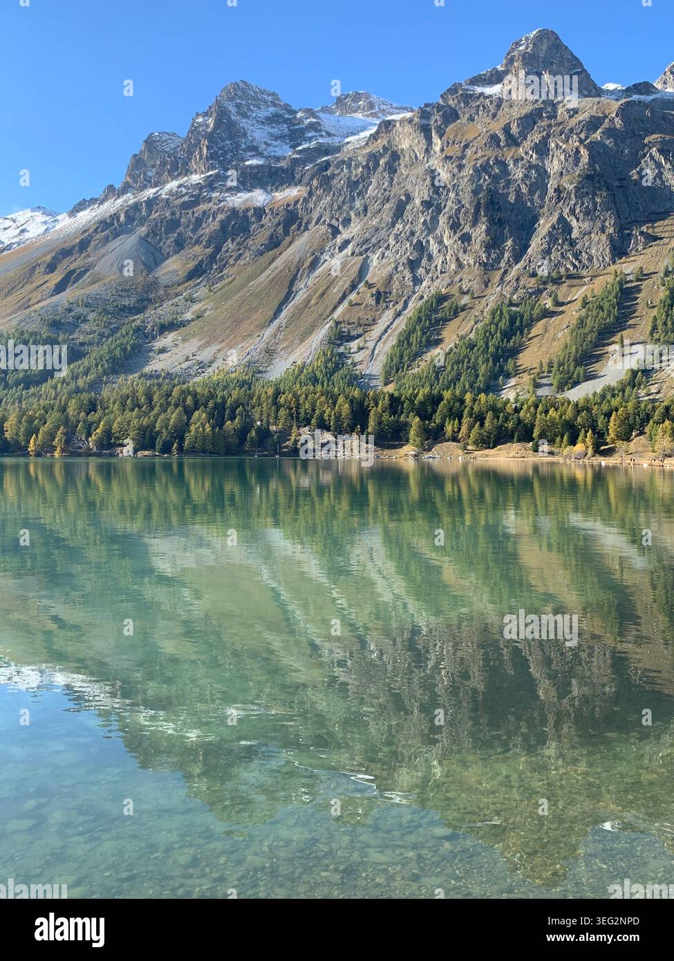 Vista delle montagne di ottobre vicino a Sils Maria con un lago alpino simile a uno specchio che riflette le cime circostanti delle Alpi svizzere. - Immagine stock catturata con smartphone
