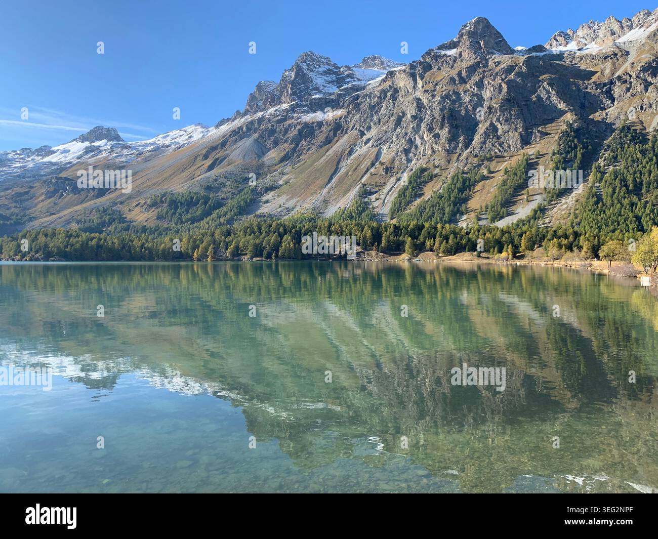 Vista delle montagne di ottobre vicino a Sils Maria con un lago alpino simile a uno specchio che riflette le cime circostanti delle Alpi svizzere. - Immagine stock catturata con smartphone