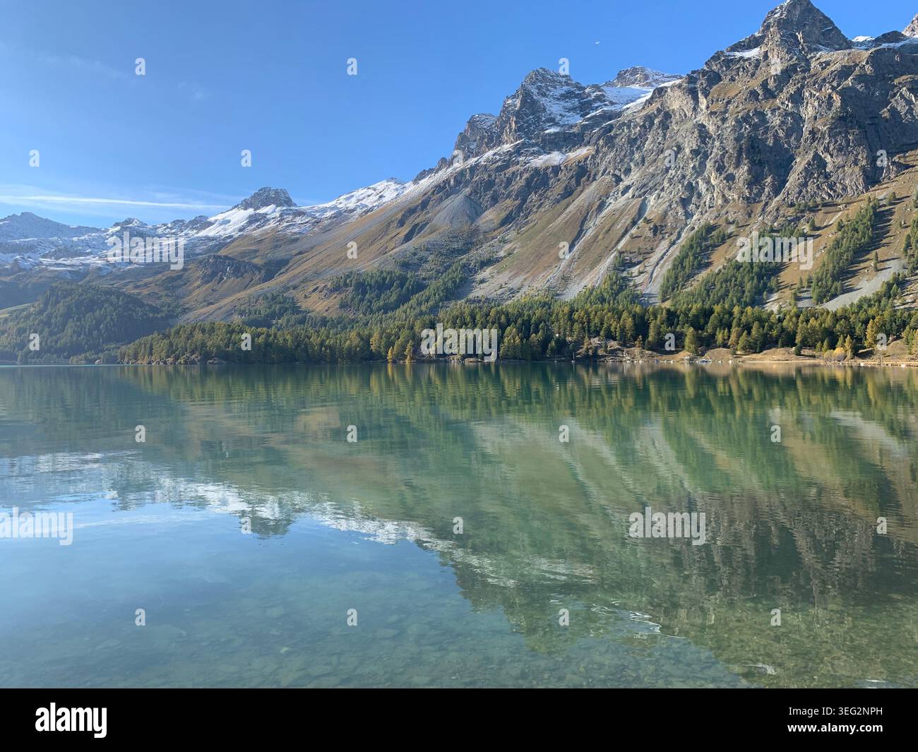 Vista delle montagne di ottobre vicino a Sils Maria con un lago alpino simile a uno specchio che riflette le cime circostanti delle Alpi svizzere. - Immagine stock catturata con smartphone