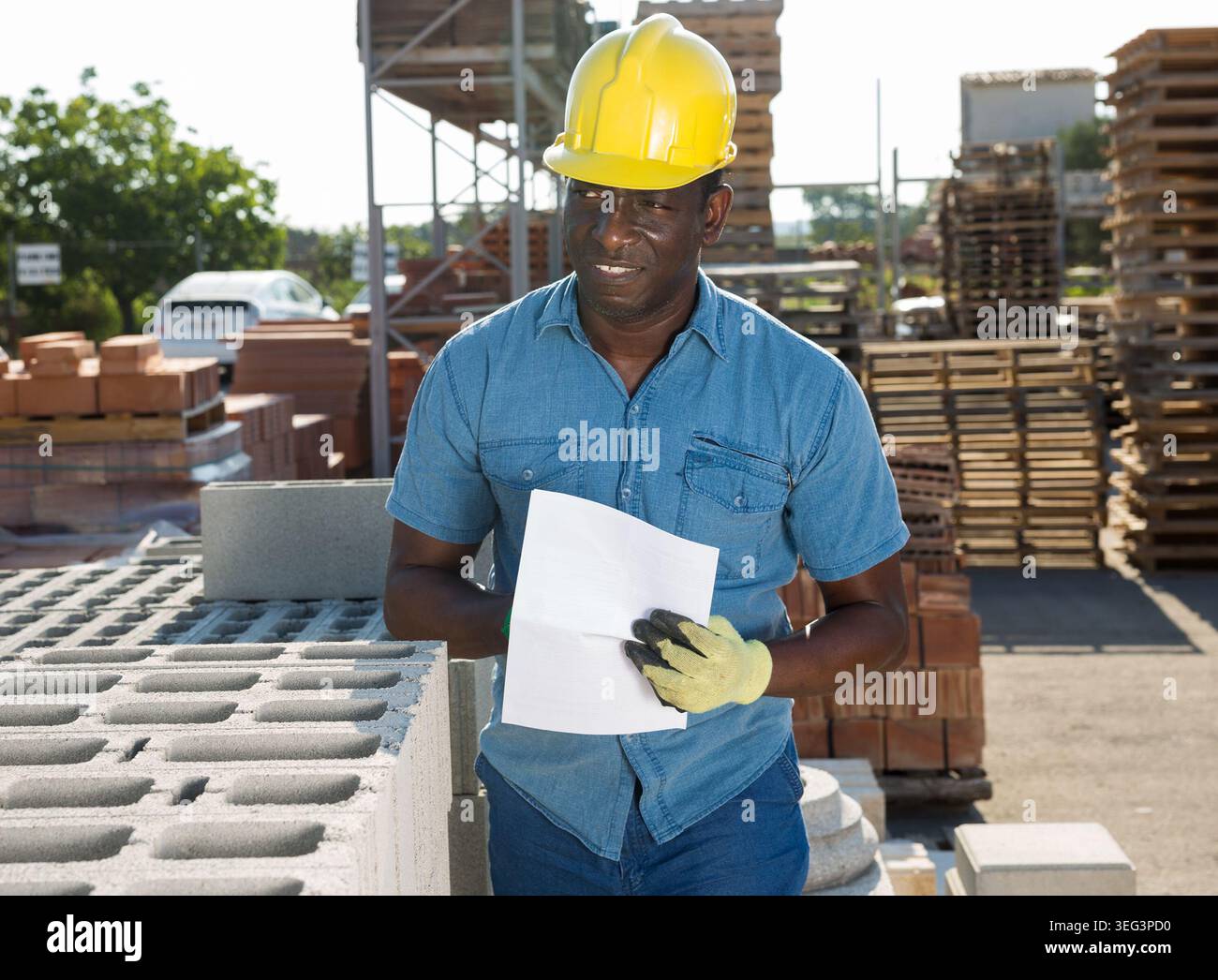 Uomo lavoratore che controlla la quantità di mattoni nel negozio di hardware Foto Stock