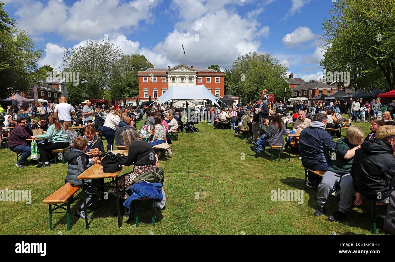 Il Warrington Food & drink Festival affolla sul prato del municipio, Bank Park, Sankey Street, con bancarelle, posti a sedere e sole primaverile Foto Stock