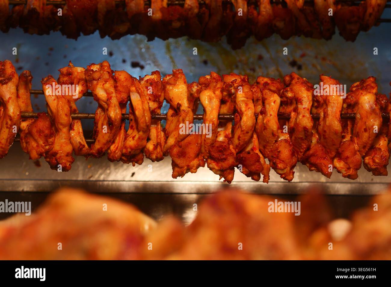 Le ali di pollo vengono cucinate in uno stand di cibo di strada Foto Stock