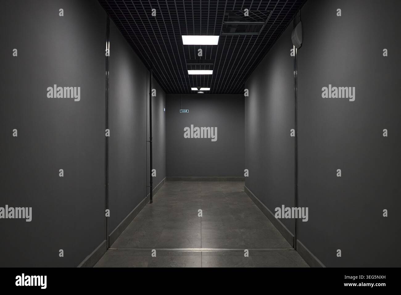 Corridoio Dark Office che porta all'uscita di emergenza per il concetto di sicurezza Foto Stock