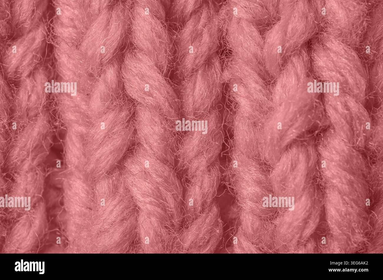 Trama dettagliata di filato rosa tenue con fibre visibili e cuciture intrecciate che creano profondità e dimensioni Foto Stock