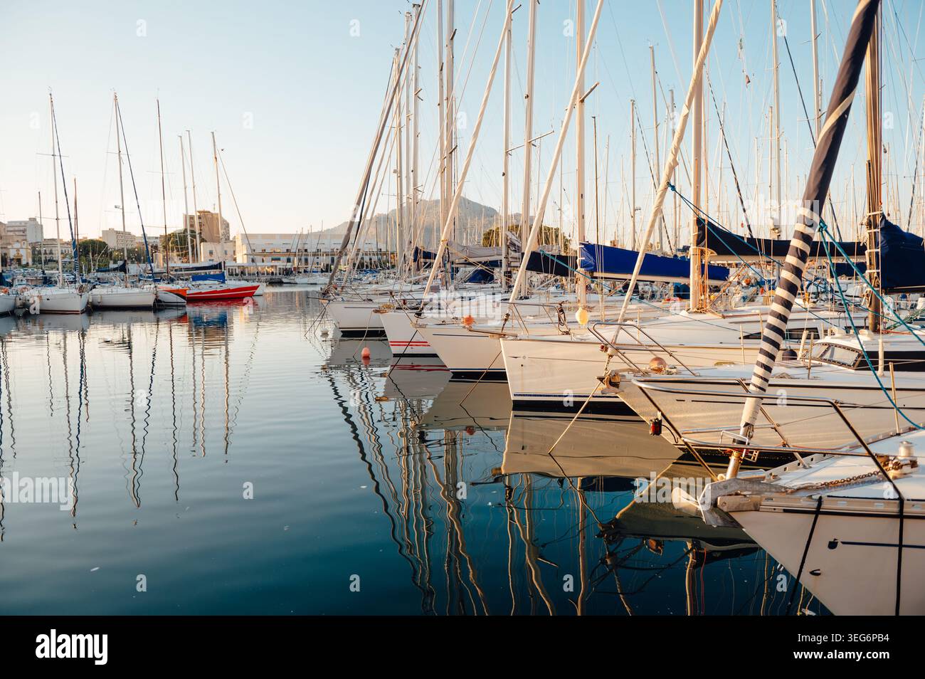 Barche a vela attraccate in un porticciolo con riflessi in acque calme a Palermo Foto Stock
