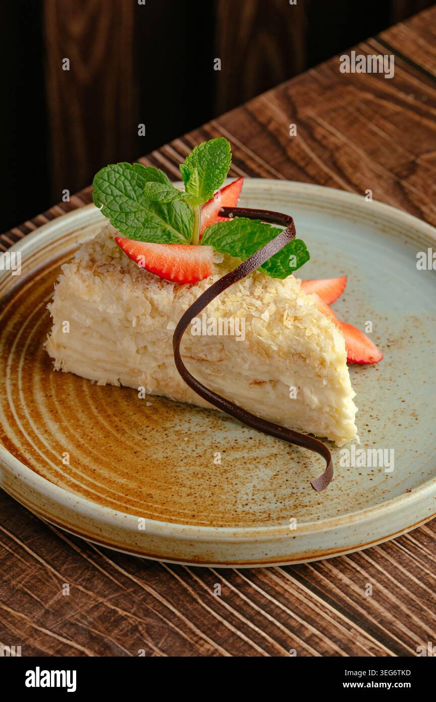 Fetta di torta napoleone gourmet con fragole e menta Foto Stock