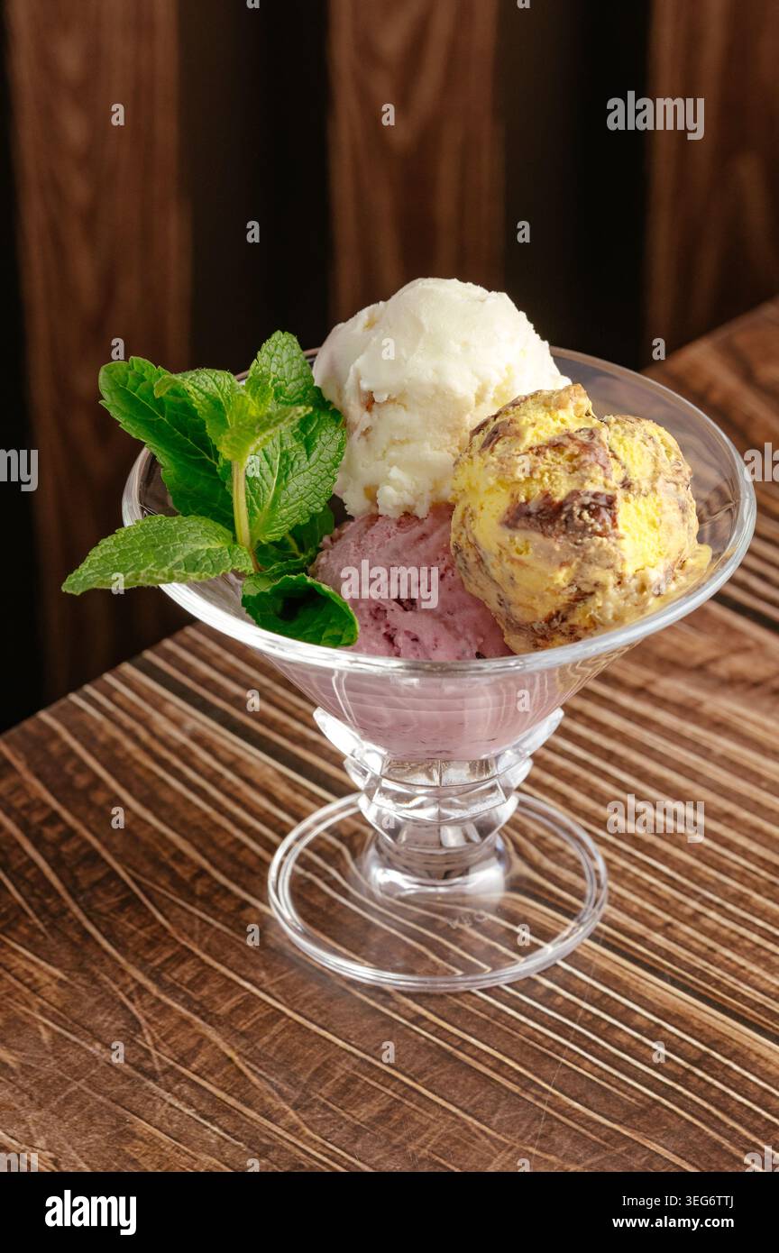 Sessole per gelato assortite con guarnizione alla menta in un piatto di vetro Foto Stock