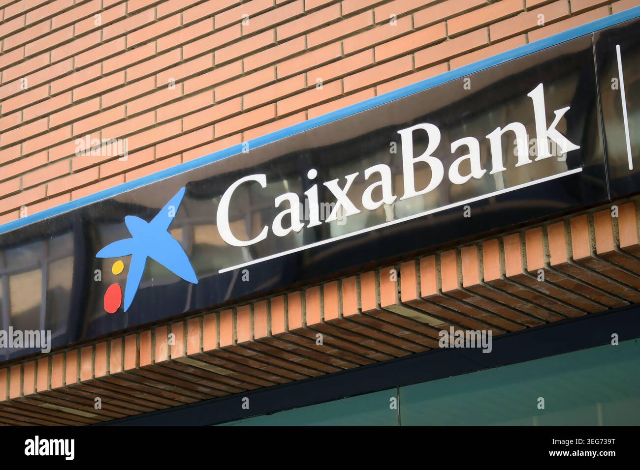 Il logo bancario della CaixaBank è esposto all'esterno della filiale finanziaria di Siviglia, Spagna Foto Stock