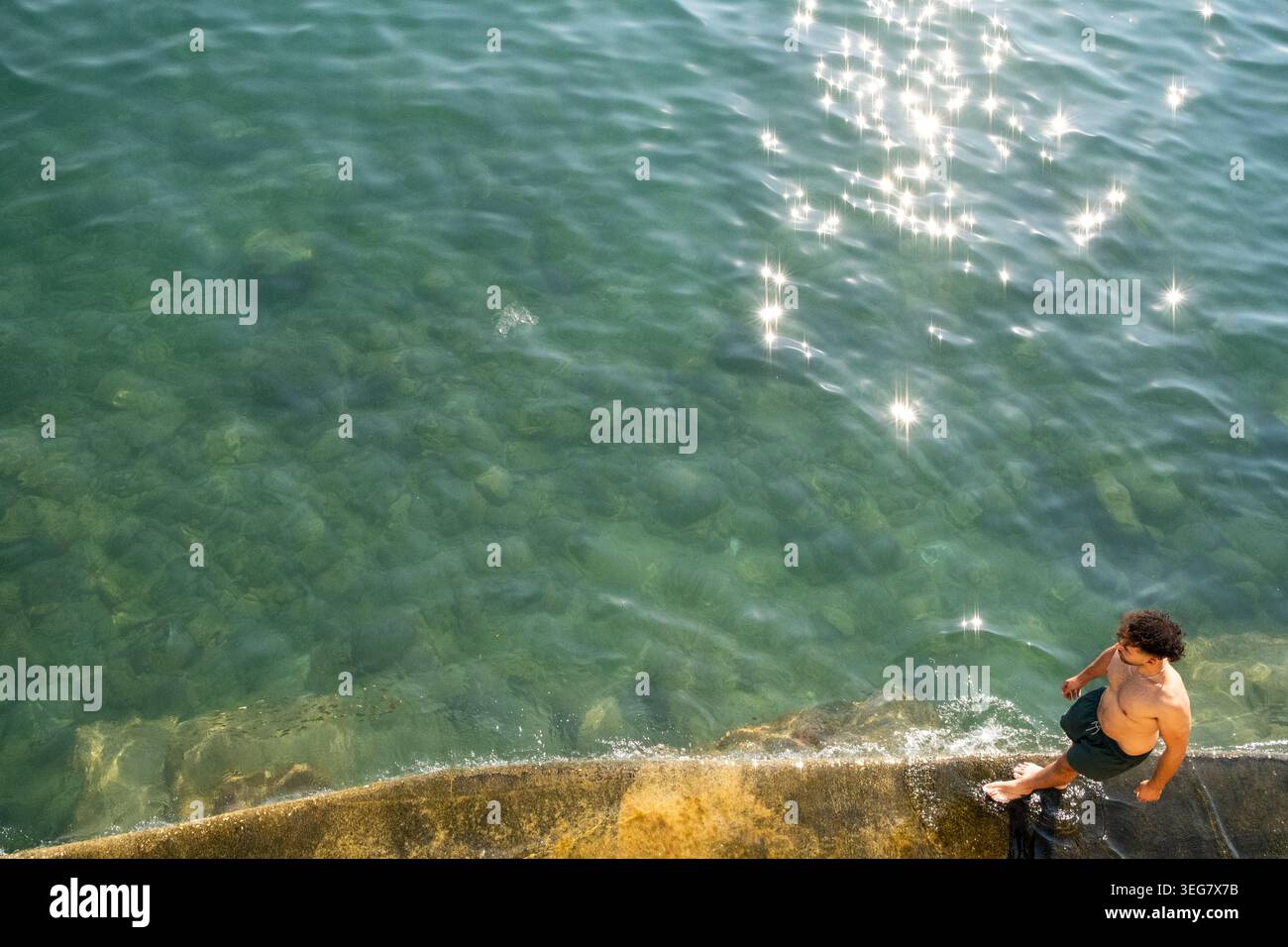 Vista ad alto angolo di un nuotatore in riva al mare nella baia di Rinella a Kalkara, regione sud-orientale, Malta, 9 agosto 2025. L'immagine mostra Clear (chiaro) Foto Stock