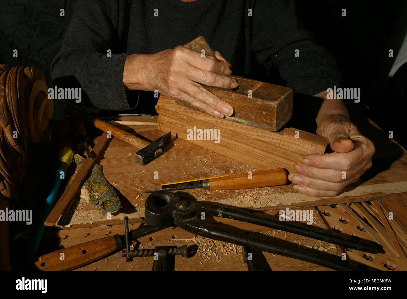 Il lavoratore professionista del legno costruisce con cura mobili sofisticati utilizzando metodi tradizionali Foto Stock