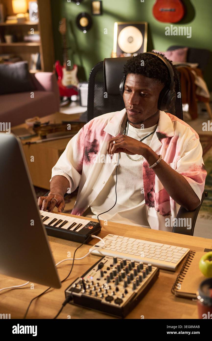 Black Young Man che produce musica in Home Studio per la creazione di contenuti Foto Stock