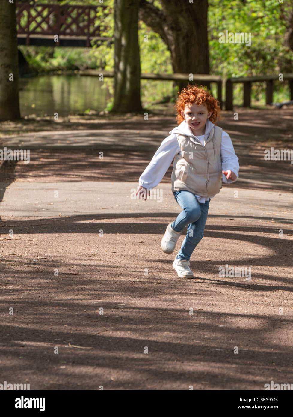bambino dalla testa rossa che corre nel parcheggio locke, redcar. Foto Stock