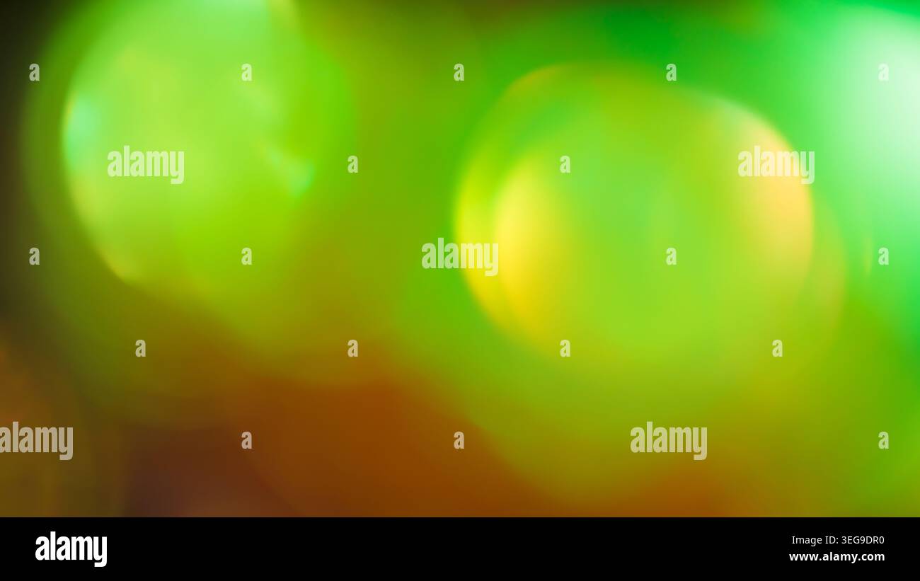 Sfocatura bokeh verde e giallo brillante con effetto flare luminoso dell'obiettivo per una sovrapposizione di design Foto Stock