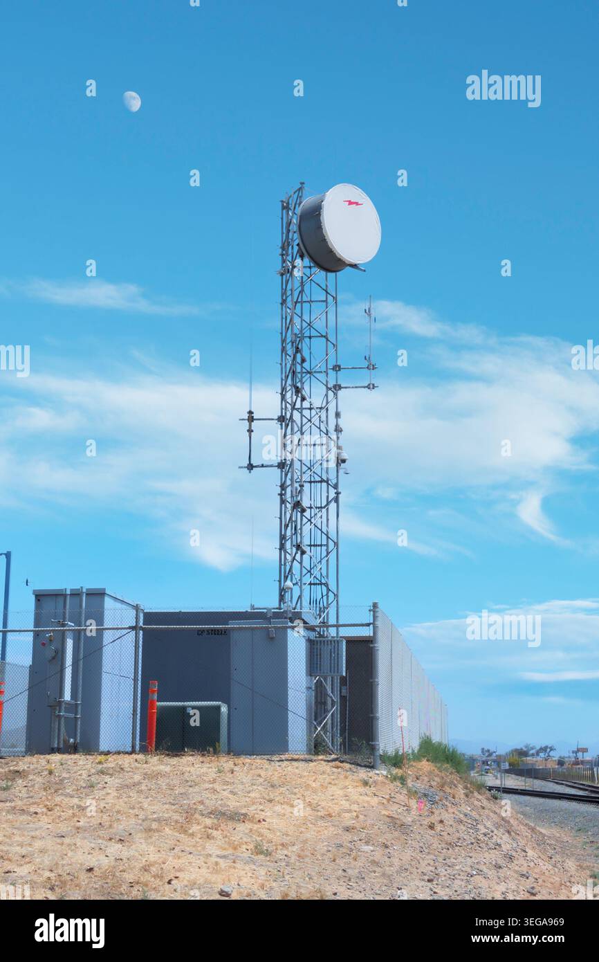 Torre per telecomunicazioni con piastra per microonde sotto il cielo blu Foto Stock