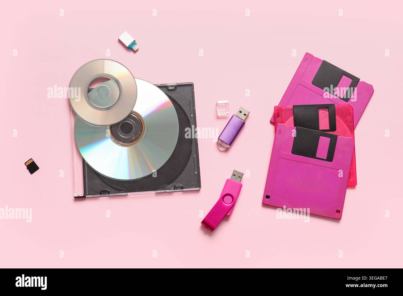 CD, unità flash USB e floppy disk su sfondo rosa Foto Stock