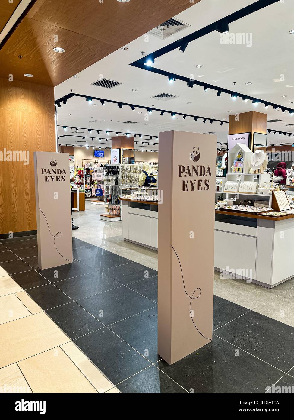 Kuala Lumpur, Malesia, 12 aprile 2026: Ingresso moderno al negozio Panda Eyes con colonne beige, illuminazione luminosa e mostre organizzate. Foto Stock