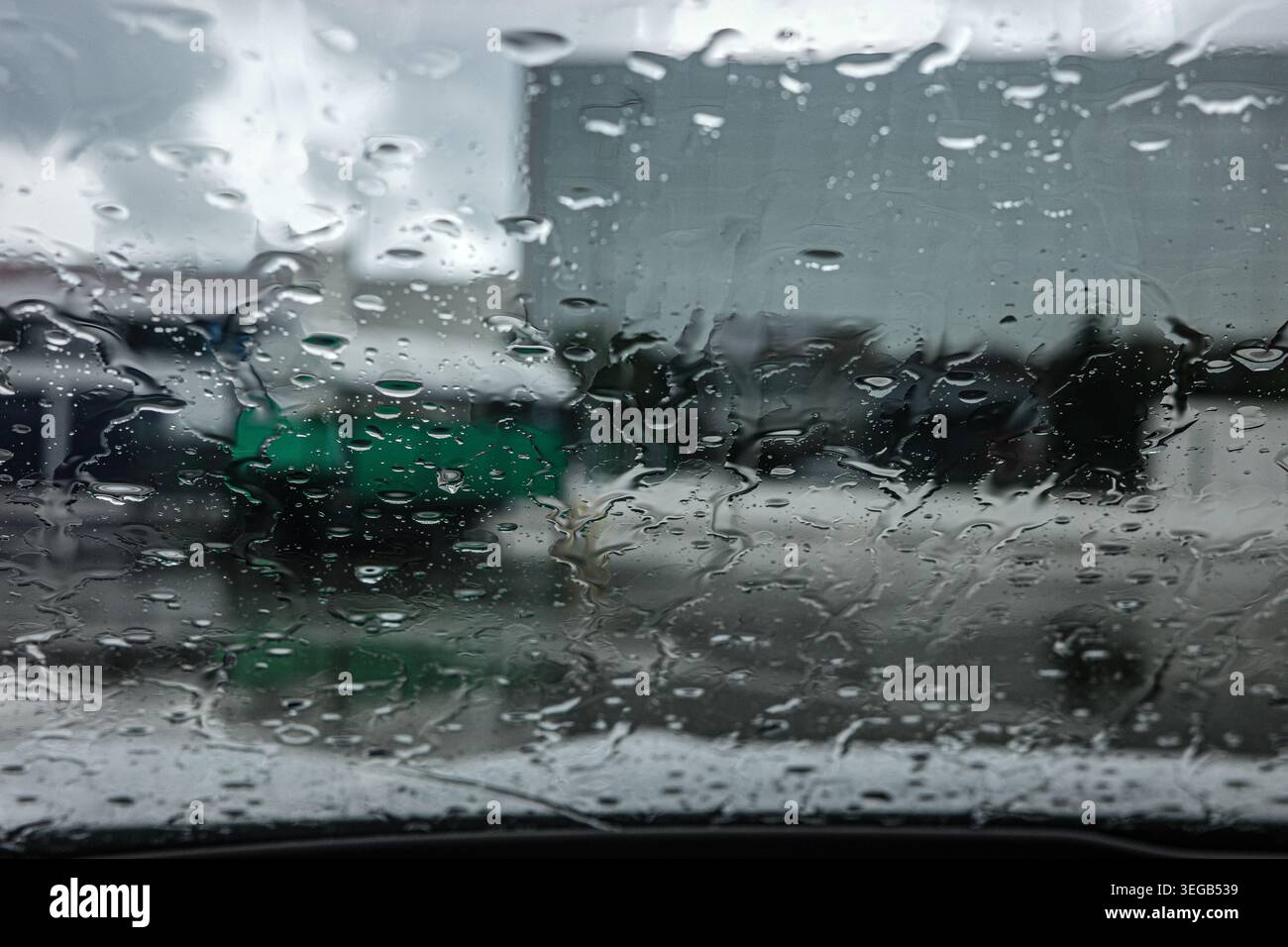 Gocce di pioggia sul vetro della finestra con sfondo sfocato Foto Stock