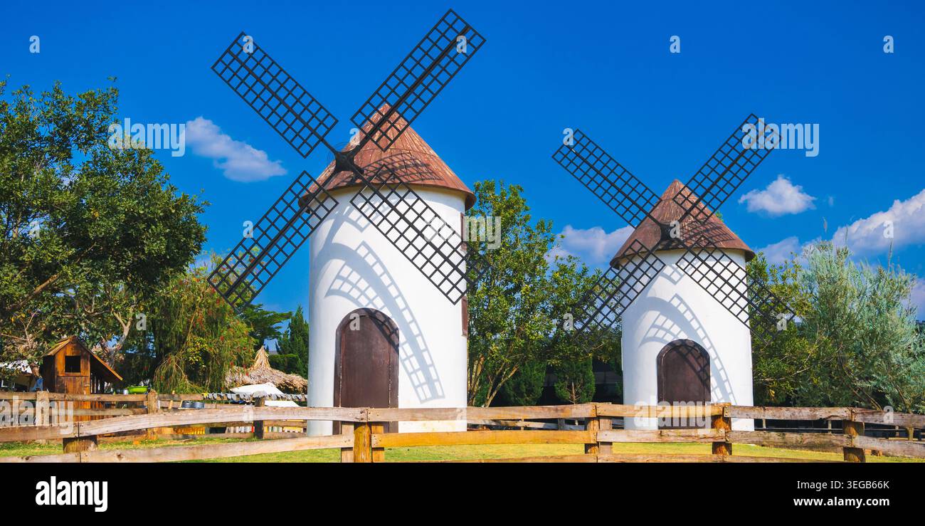 mulini a vento bianchi gemelli con cielo limpido e paesaggio rurale Foto Stock