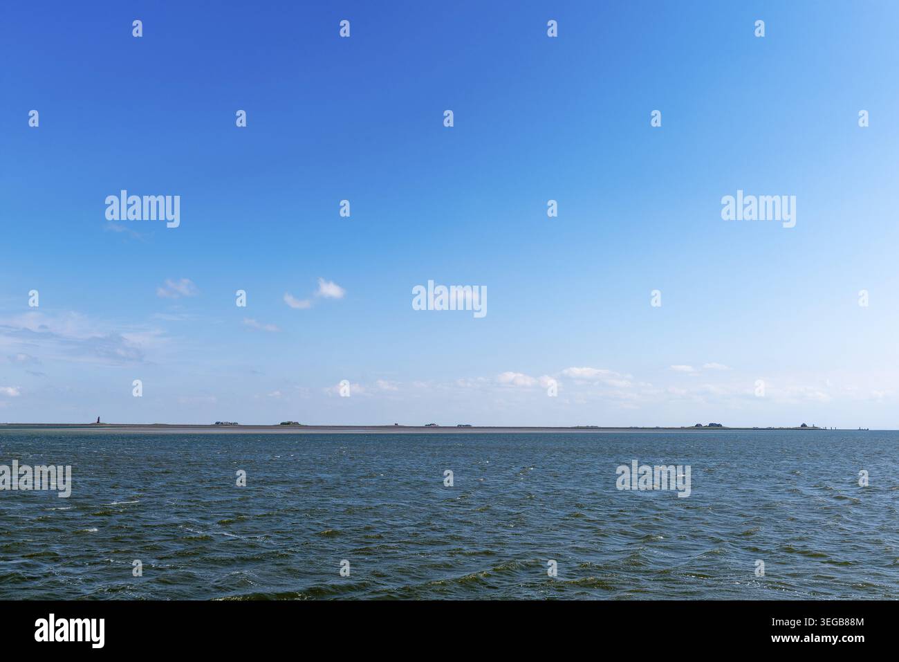 Hallig Langeness nel Parco Nazionale del Mare di Wadden dello Schleswig-Holstein con faro (a sinistra) e terps, la biosfera di Halligen, la Frisia settentrionale, la primavera, la blu S Foto Stock