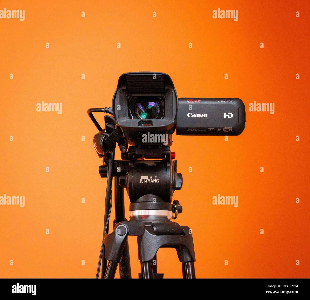 Registratore Canon Cam su un treppiede con sfondo arancione chiaro Foto Stock