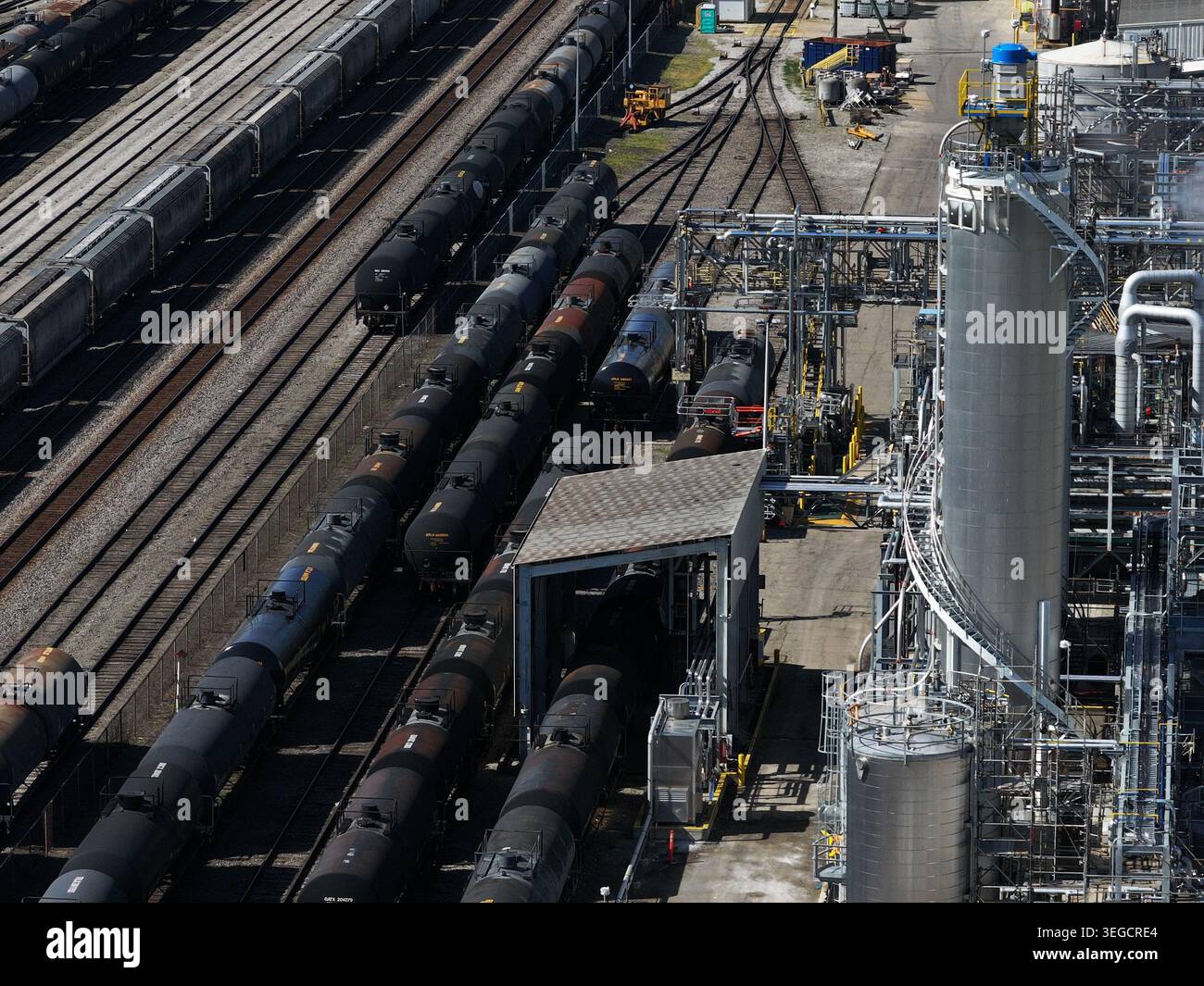 Vista aerea delle autocisterne nere sui binari ferroviari presso una raffineria industriale con serbatoi di stoccaggio e tubazioni complesse a Cincinnati, OHIO, United St Foto Stock