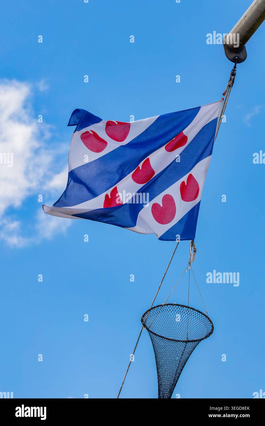 Bandiera olandese della provincia Frisia appesa su una corda di una nave da pesca Foto Stock