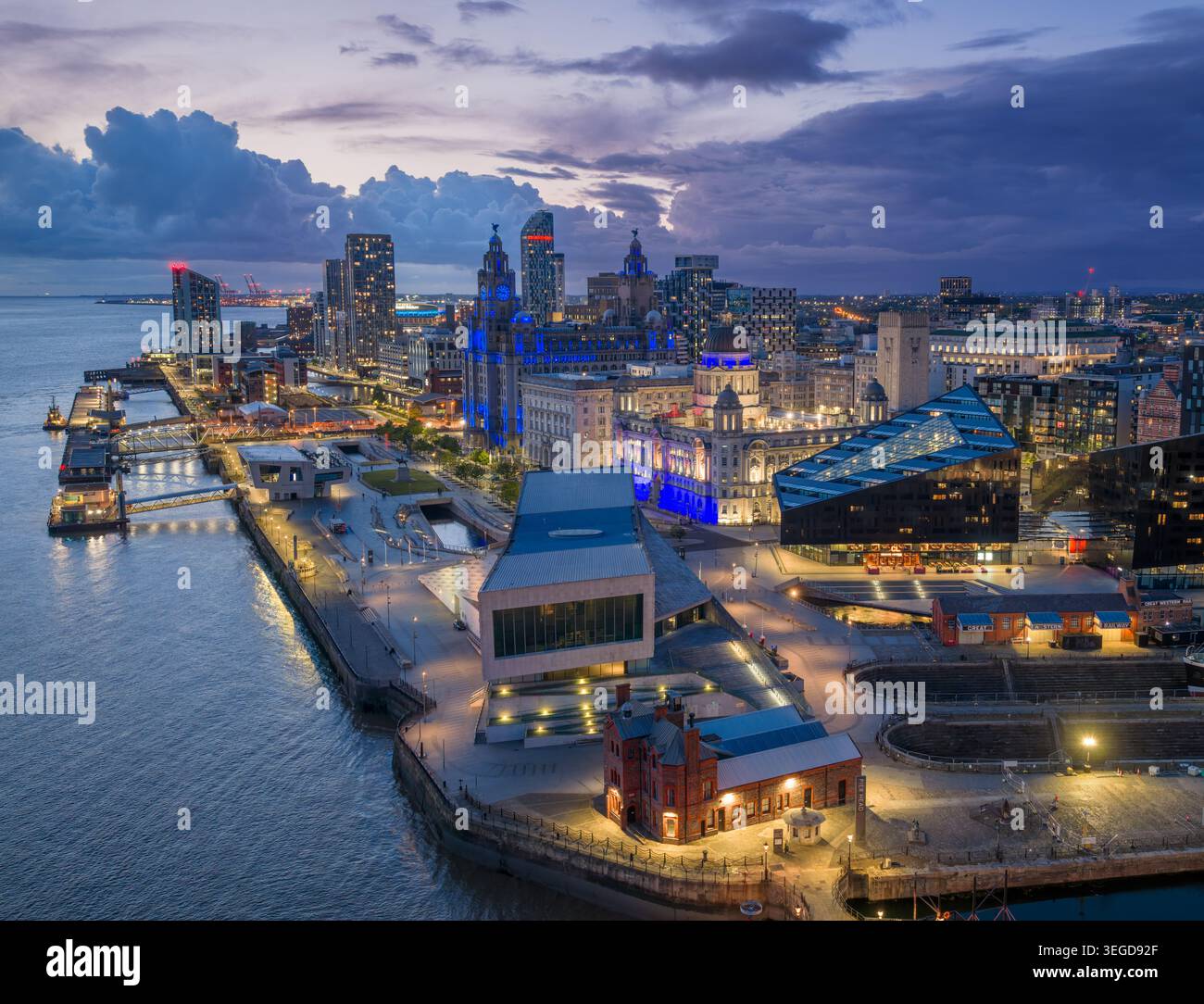 Fronte marittima di Liverpool di notte con il Royal Liver Building illuminato, Pier Head e lo skyline del fiume Mersey nel Merseyside, Inghilterra. Foto Stock